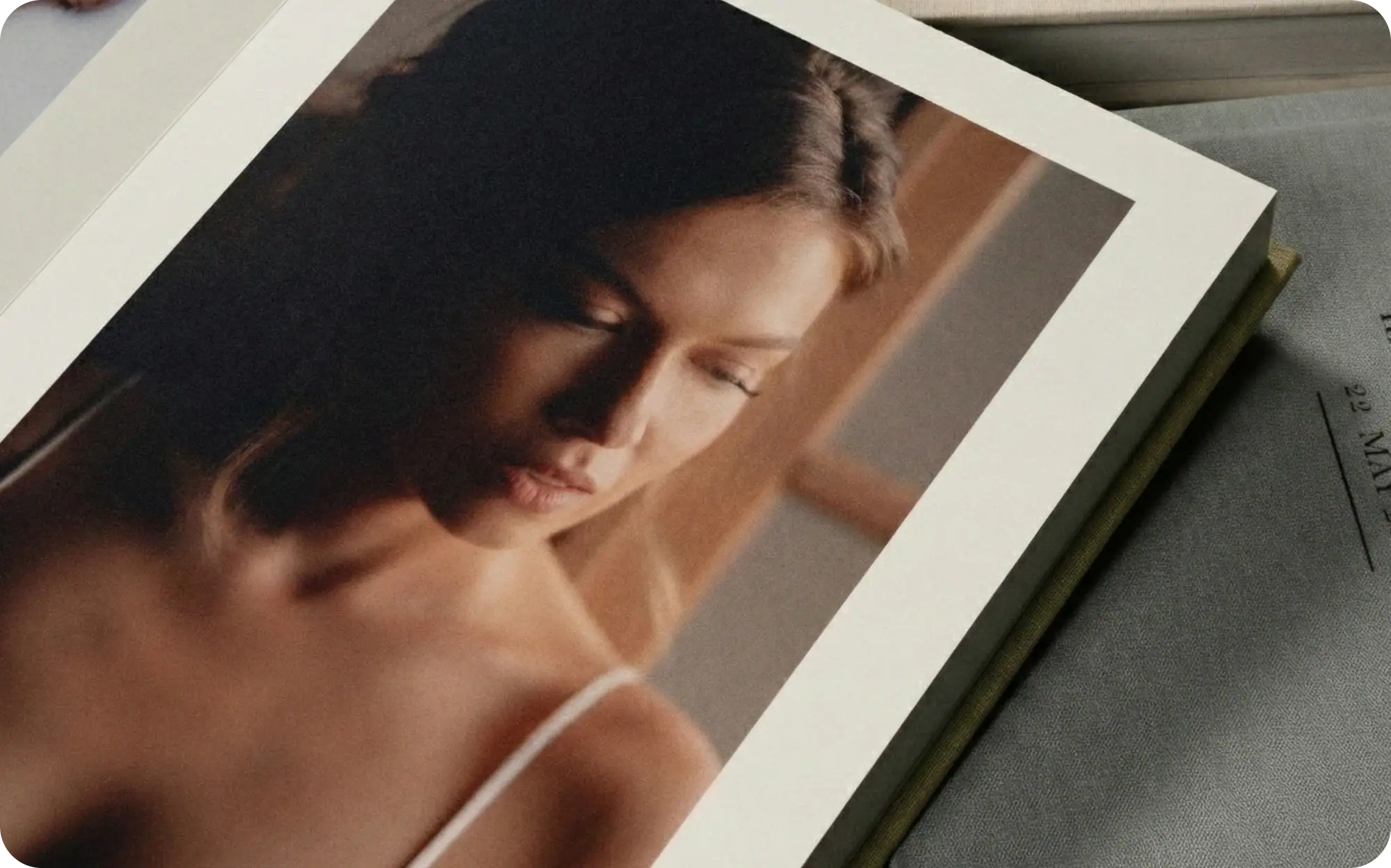 Close-up of a woman with long hair, looking down thoughtfully.