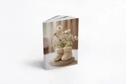 Baby shoes with flowers on a maternity album cover.
