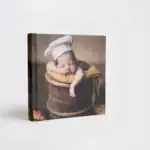 Adorable sleeping baby in a chef hat on a rustic background for New Born album.