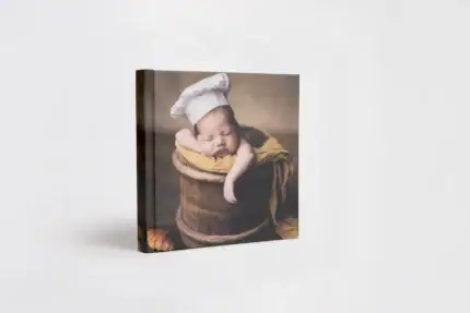 Adorable sleeping baby in a chef hat on a rustic background for New Born album.