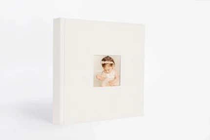 Elegant white photo album with a small picture window for special memories.