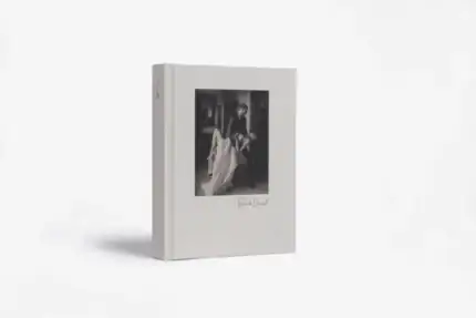 Black and white photo of a woman reading a book on the cover.